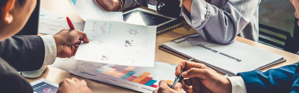 Smart businessman and businesswoman talking discussion in group meeting at office table in a modern office interior. Business collaboration strategic planning and brainstorming of coworkers.